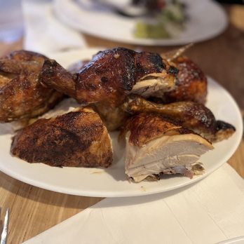 Brasa signature dishes Rotisserie Chicken, Slow-Roasted Pork, Collard Greens, Cornbread, Yams with Andouille Sausage